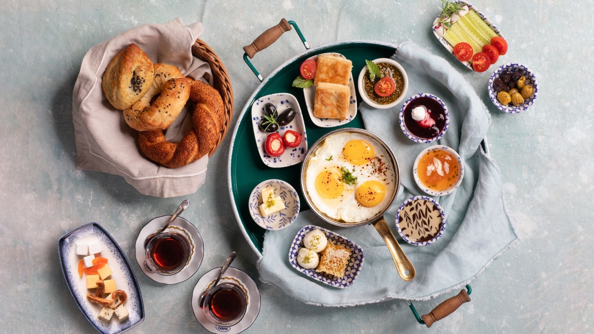 Full Turkish breakfast tray with simit, eggs, olives, jams and tea